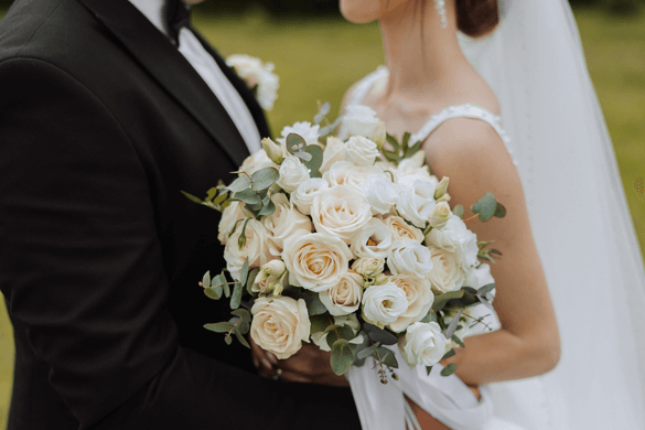 close up shot of a bride and groom with flowers 
