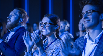 a group of people clapping at a convention