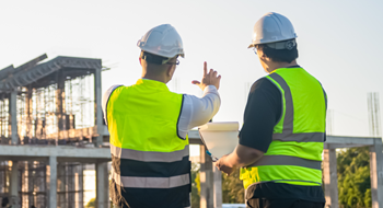 construction workers discussing project plans at a busy worksite